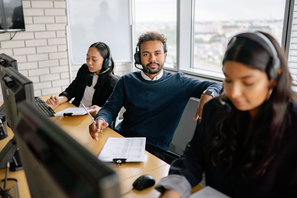 A focused call center team attending customer calls in a modern office setting.